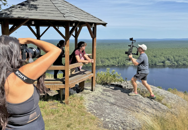 Two people taking photos of a person in a gazebo